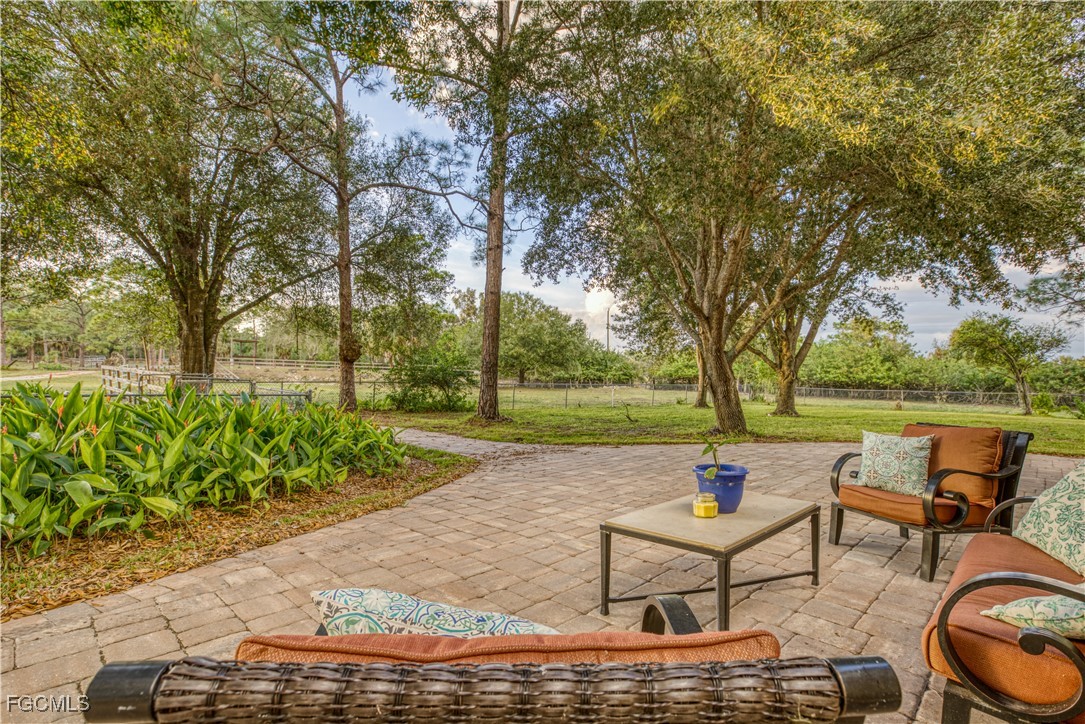 19740 Gottarde Road North Fort Myers, FL 33917 - Photo 4 of 12 a view of a lake with couches and table and chairs under an umbrella