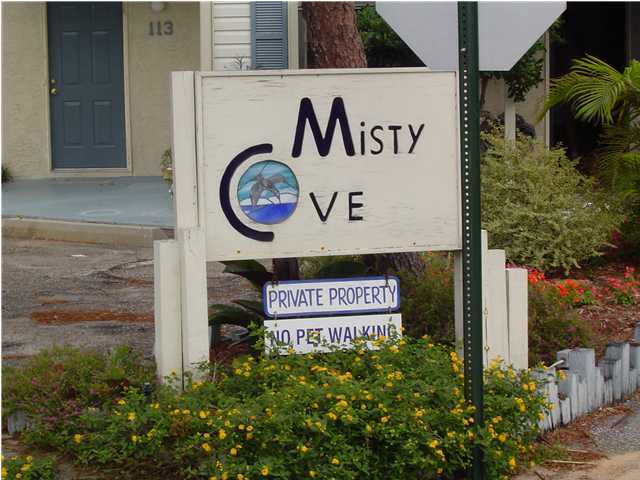 71 Misty Cove, Unit 207 Destin, FL 32550 - Photo 2 of 9 a sign broad on the wooden wall
