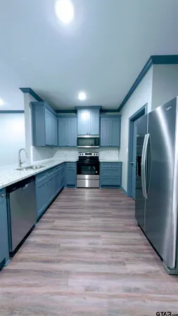 a large kitchen with kitchen island a sink stainless steel appliances and cabinets