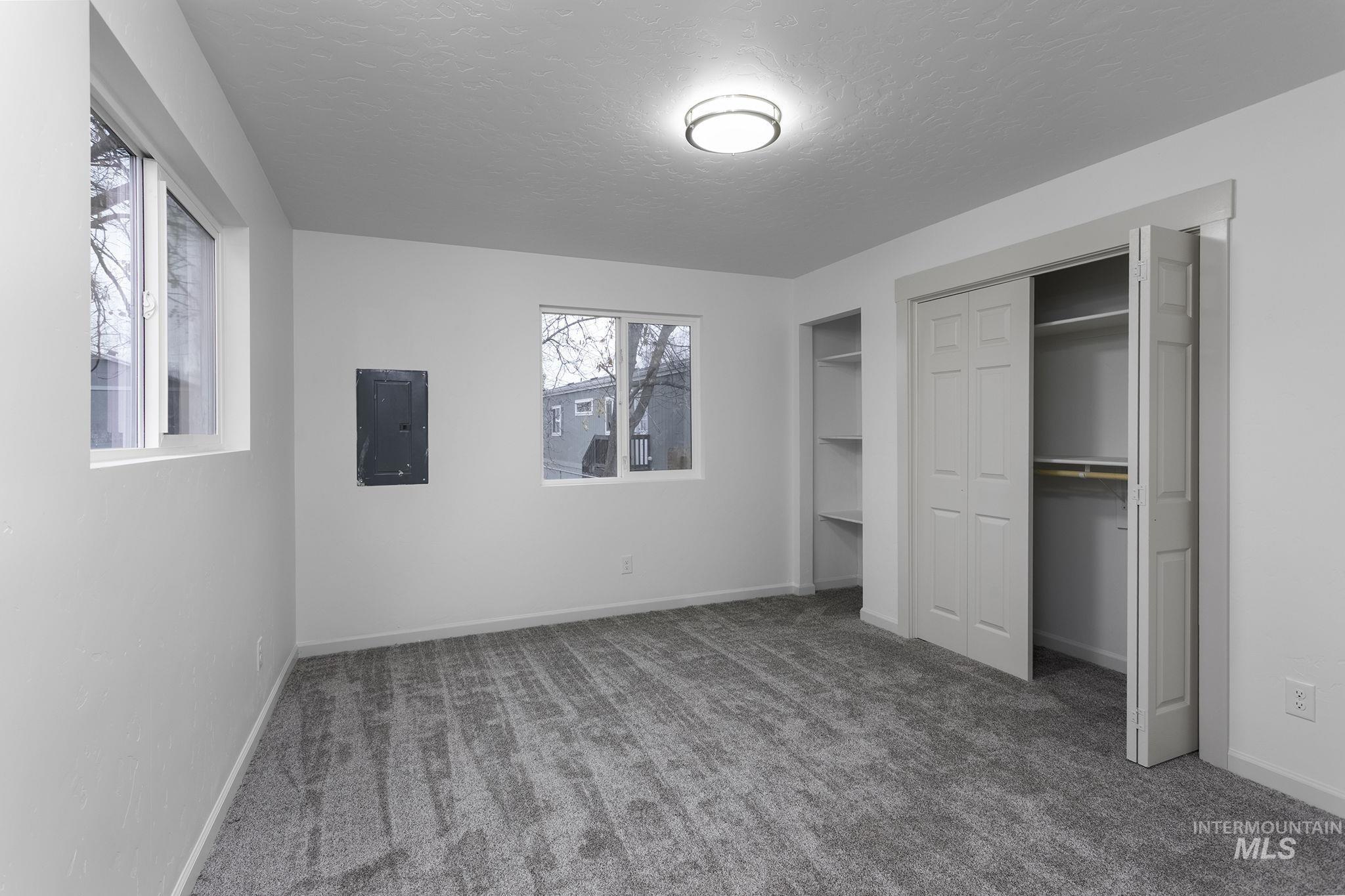 450 Greenleaf Street Boise, ID 83713 - Photo 16 of 17 Unfurnished bedroom featuring carpet flooring, a textured ceiling, electric panel, and multiple closets