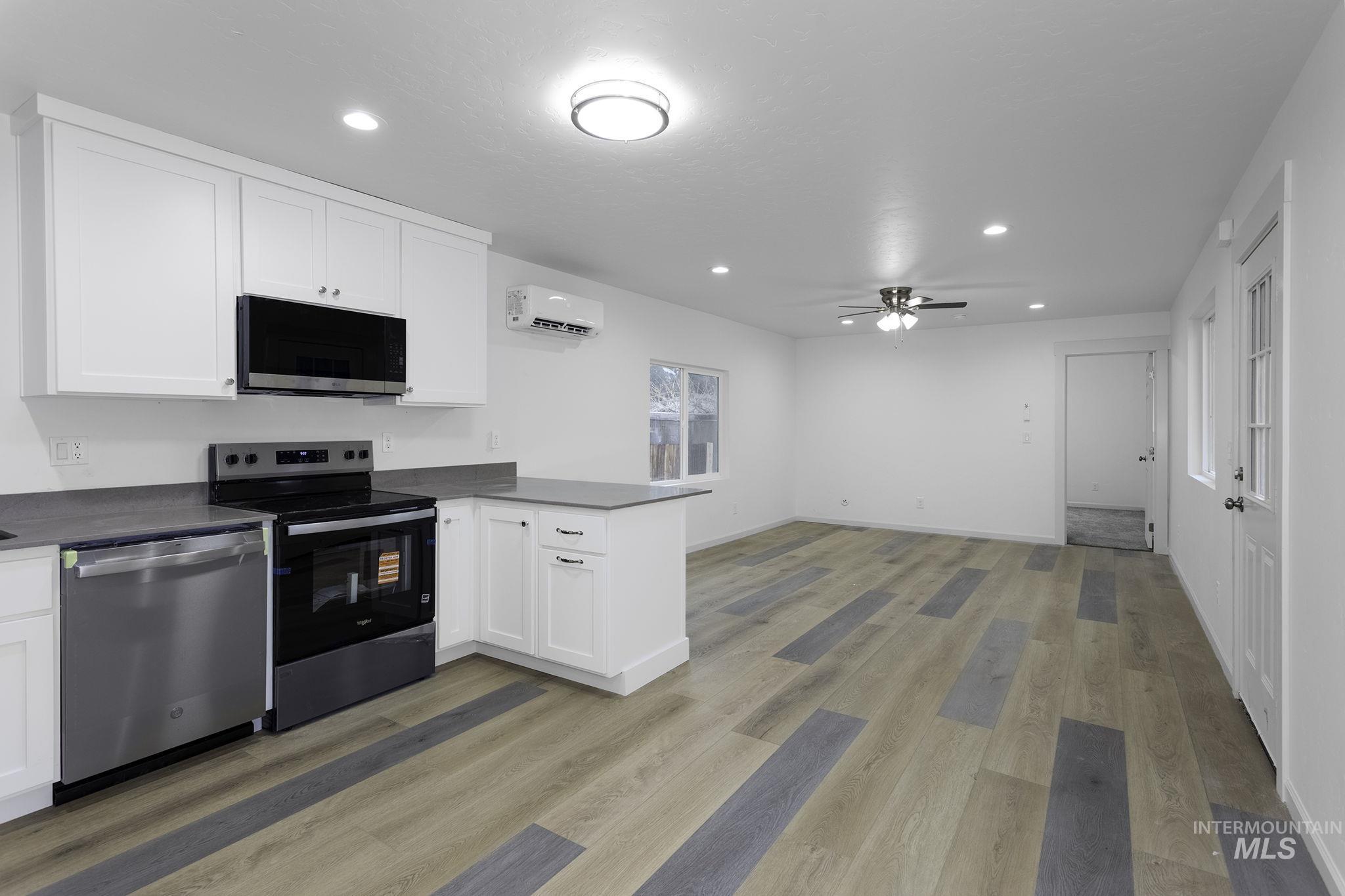 450 Greenleaf Street Boise, ID 83713 - Photo 3 of 17 Kitchen with a peninsula, stainless steel appliances, white cabinetry, recessed lighting, and dark countertops