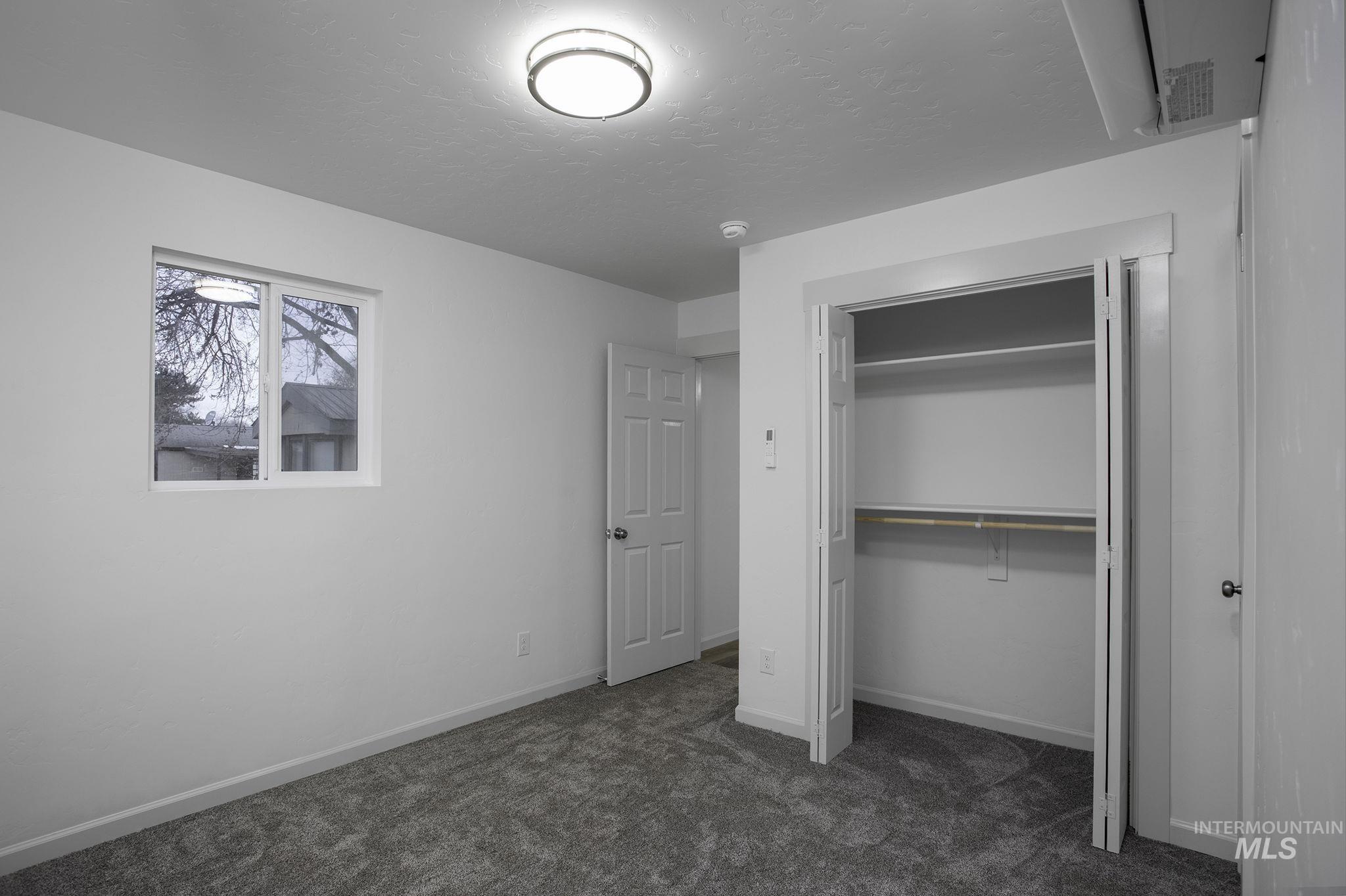 450 Greenleaf Street Boise, ID 83713 - Photo 10 of 17 Unfurnished bedroom with dark carpet, a closet, and a textured ceiling