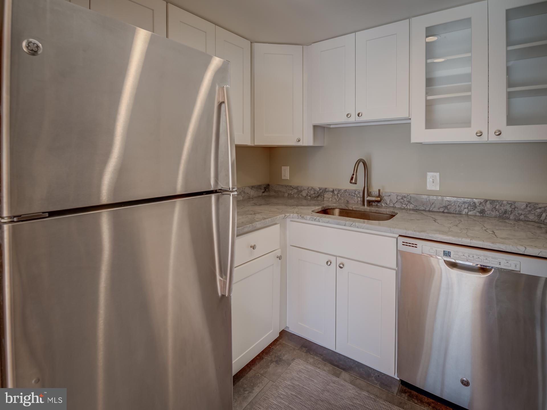 3210 Grace Street Northwest, Unit 309 Washington, DC 20007 - Photo 15 of 43 a white refrigerator freezer sitting inside of a kitchen
