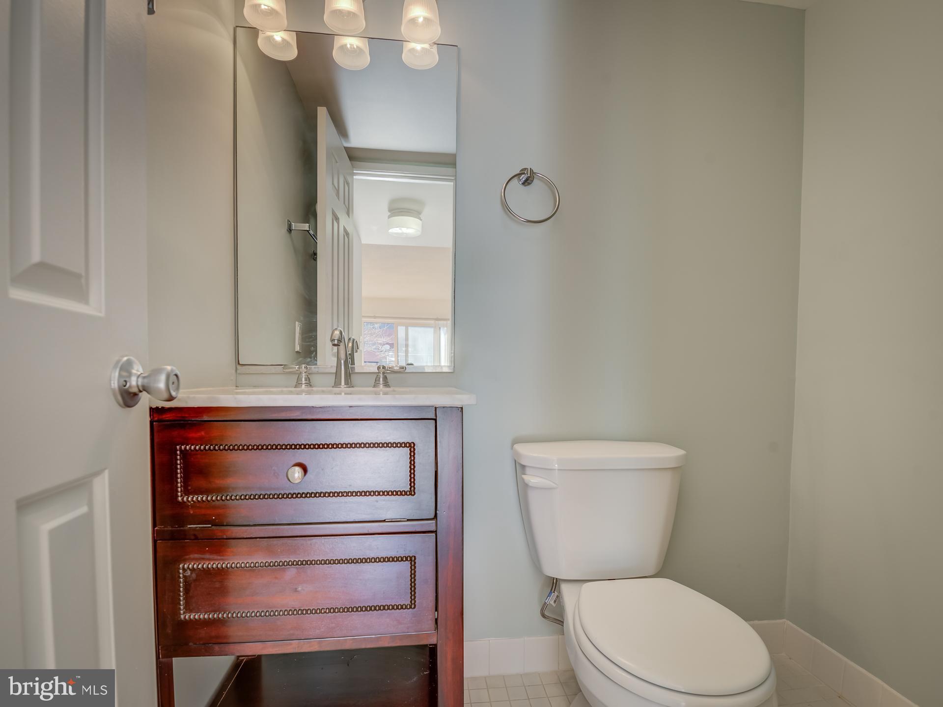 3210 Grace Street Northwest, Unit 309 Washington, DC 20007 - Photo 16 of 43 a bathroom with a toilet a sink and mirror