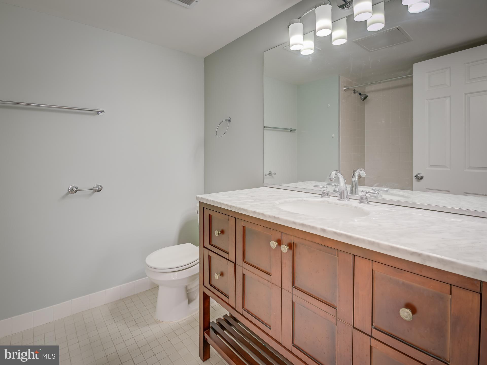 3210 Grace Street Northwest, Unit 309 Washington, DC 20007 - Photo 23 of 43 a bathroom with a granite countertop sink a toilet and a mirror