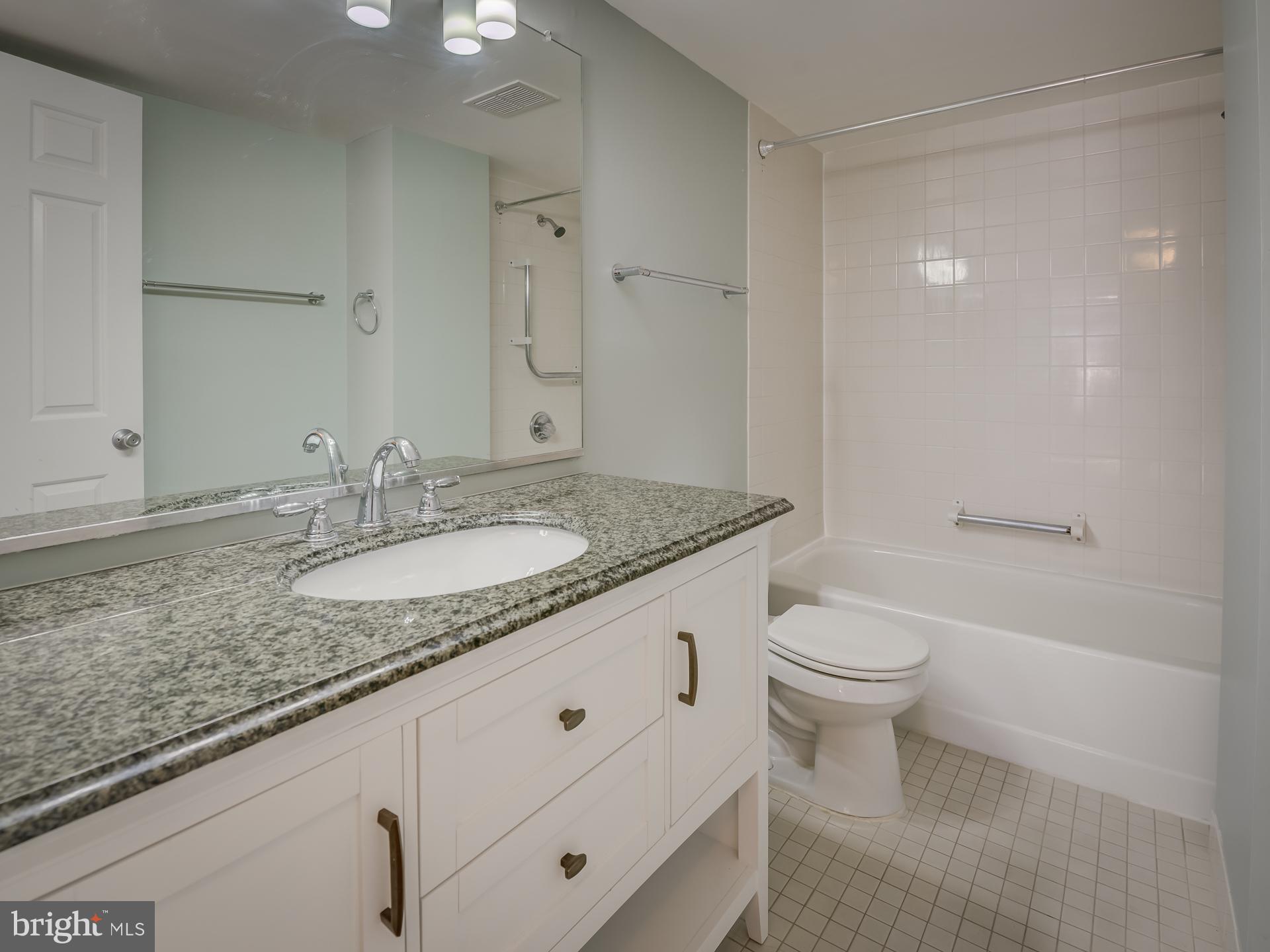 3210 Grace Street Northwest, Unit 309 Washington, DC 20007 - Photo 27 of 43 a bathroom with a granite countertop sink a toilet and shower