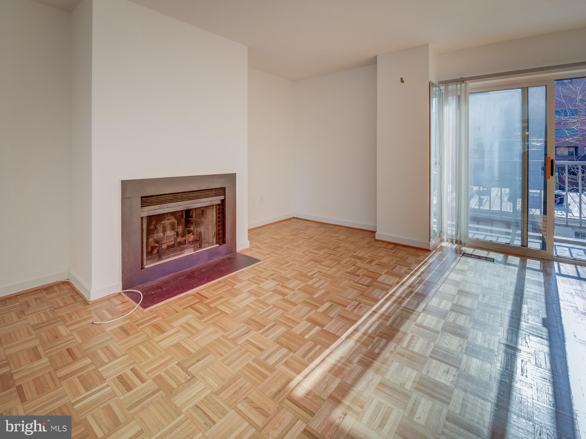 3210 Grace Street Northwest, Unit 309 Washington, DC 20007 - Photo 4 of 43 a view of empty room with floor to ceiling window and fireplace