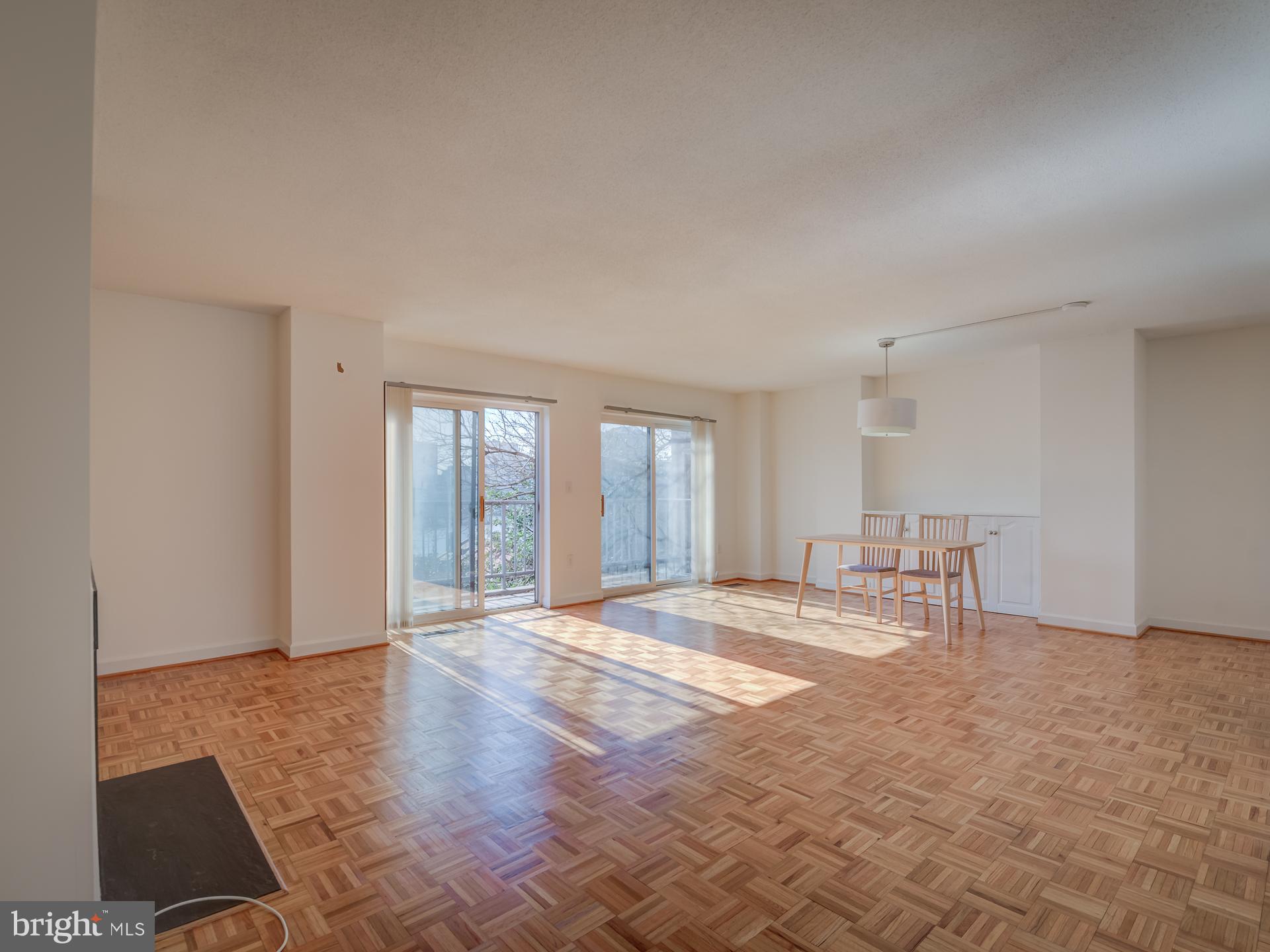 3210 Grace Street Northwest, Unit 309 Washington, DC 20007 - Photo 7 of 43 a view of an empty room with window and wooden floor