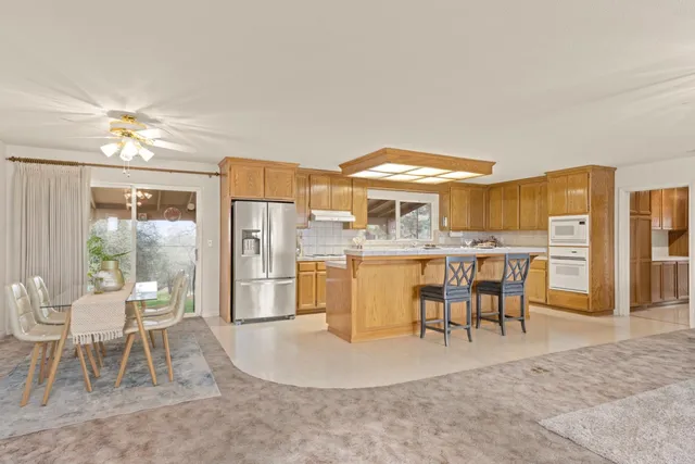 a bathroom with a granite countertop sink a toilet and mirror