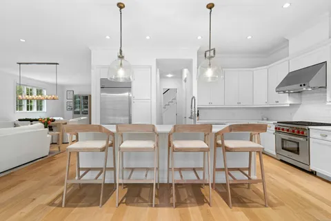 a kitchen with stainless steel appliances granite countertop a stove a kitchen island a dining table and chairs