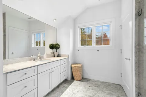 a spacious bathroom with a granite countertop sink and a mirror