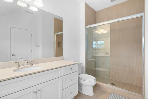 a bathroom with a sink a toilet and shower