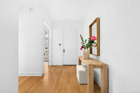 a view of a hallway with wooden floor and a potted plant