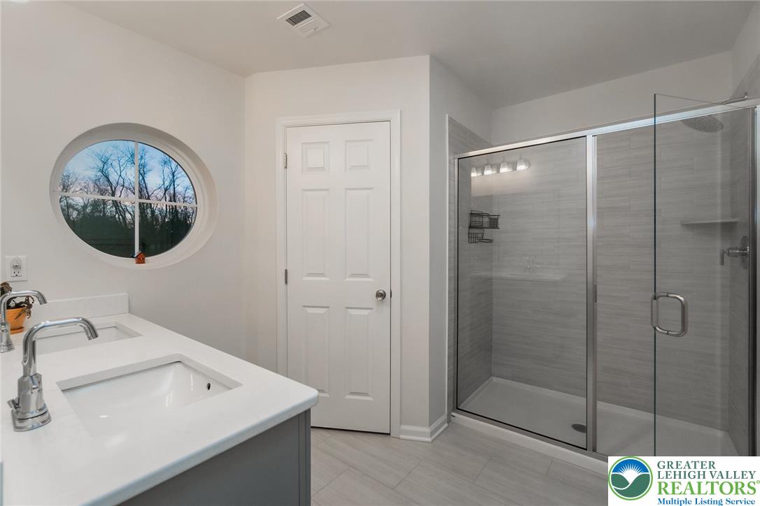 164 Maureen Lane Allentown, PA 18104 - Photo 18 of 28 a bathroom with a sink a mirror and a shower