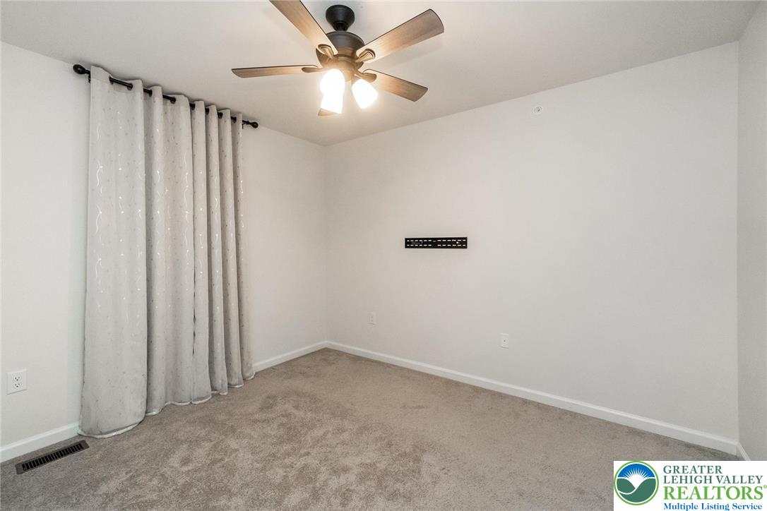 164 Maureen Lane Allentown, PA 18104 - Photo 20 of 28 an empty room with a chandelier fan and windows