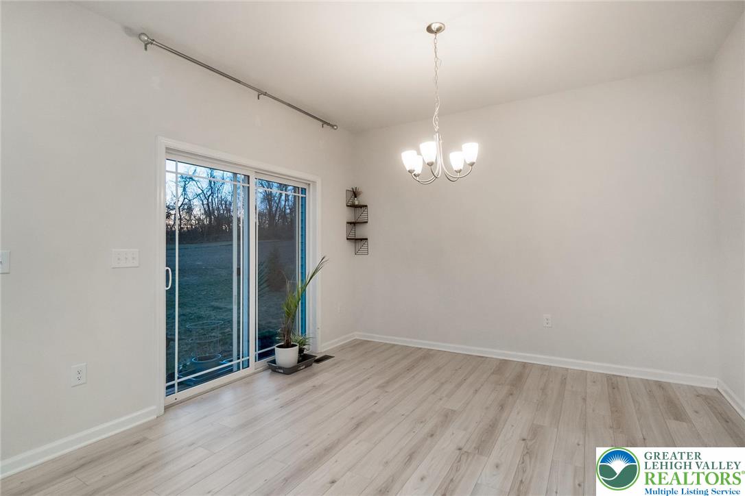 164 Maureen Lane Allentown, PA 18104 - Photo 10 of 28 an empty room with wooden floor mirror and windows