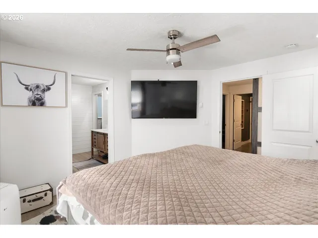 a bedroom with a bed and a flat screen tv