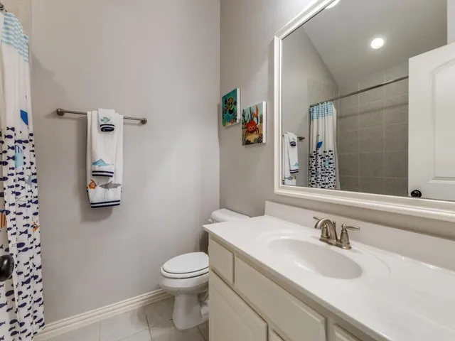 a bathroom with a granite countertop sink a toilet and a mirror