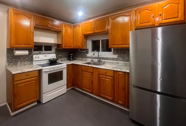 a kitchen with a sink cabinets stainless steel appliances and a refrigerator