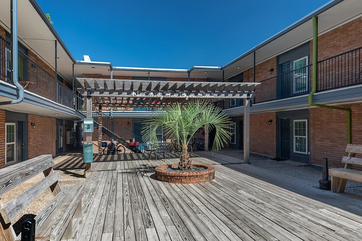 935 Byrne Street, Unit B23 Houston, TX 77009 - Photo 19 of 28 a view of a patio with table and chairs with wooden floor and floor to ceiling window