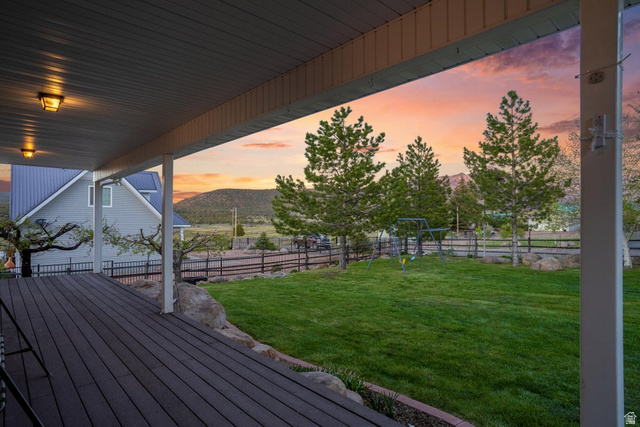 48 South Sage Road Pine Valley, UT 84781 - Photo 4 of 61 Expansive covered deck with dark wood-finish flooring extending to a lush green lawn