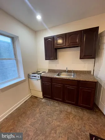 a kitchen with granite countertop a stove and a wooden cabinets