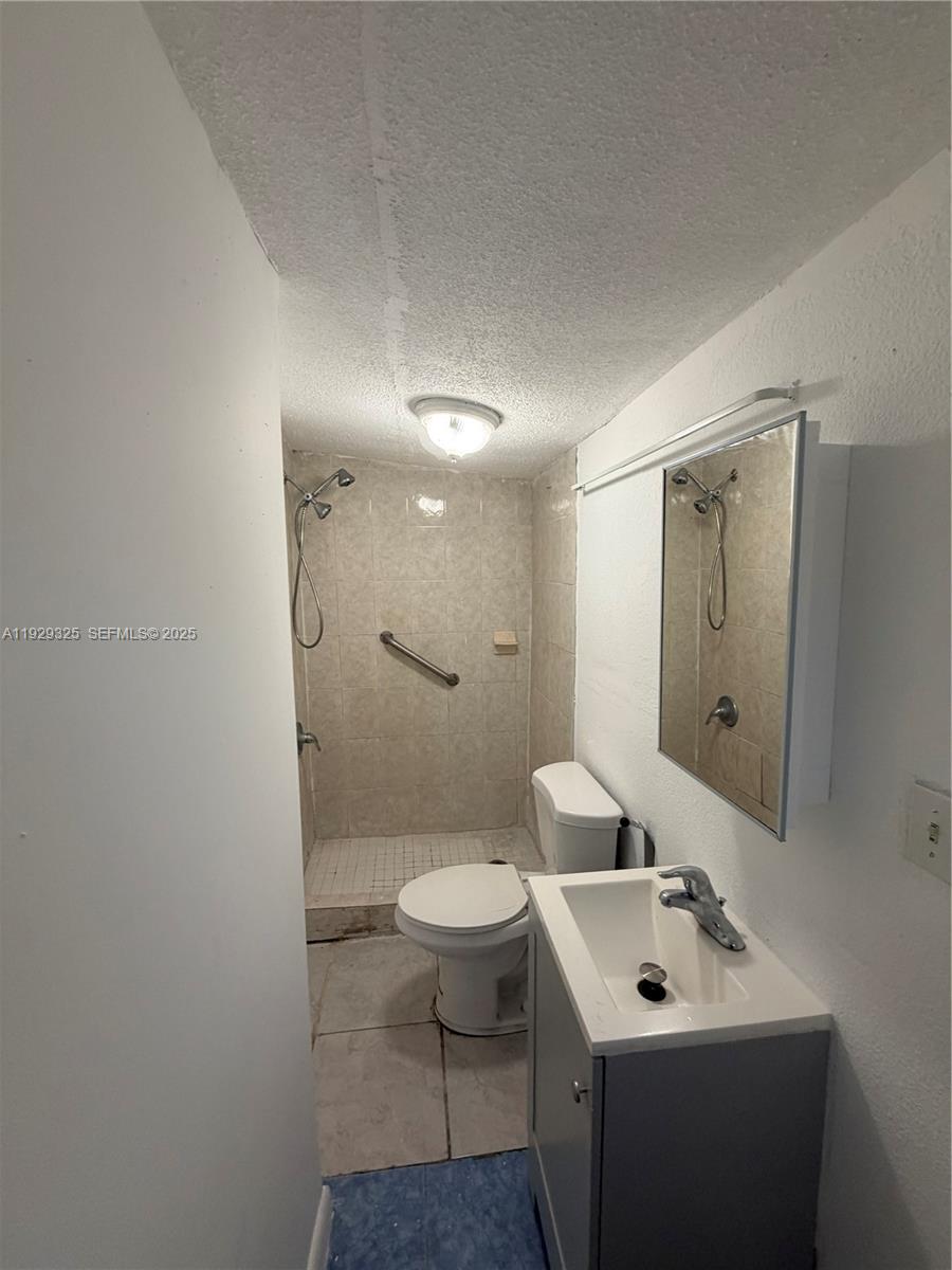 2980 Northwest 79th Street, Unit B Miami, FL 33147 - Photo 3 of 5 a bathroom with a toilet sink and mirror