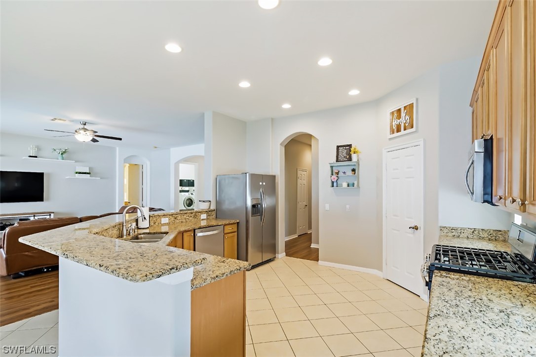12893 Timber Ridge Drive Fort Myers, FL 33913 - Photo 16 of 30 a kitchen with stainless steel appliances granite countertop a sink refrigerator and cabinets