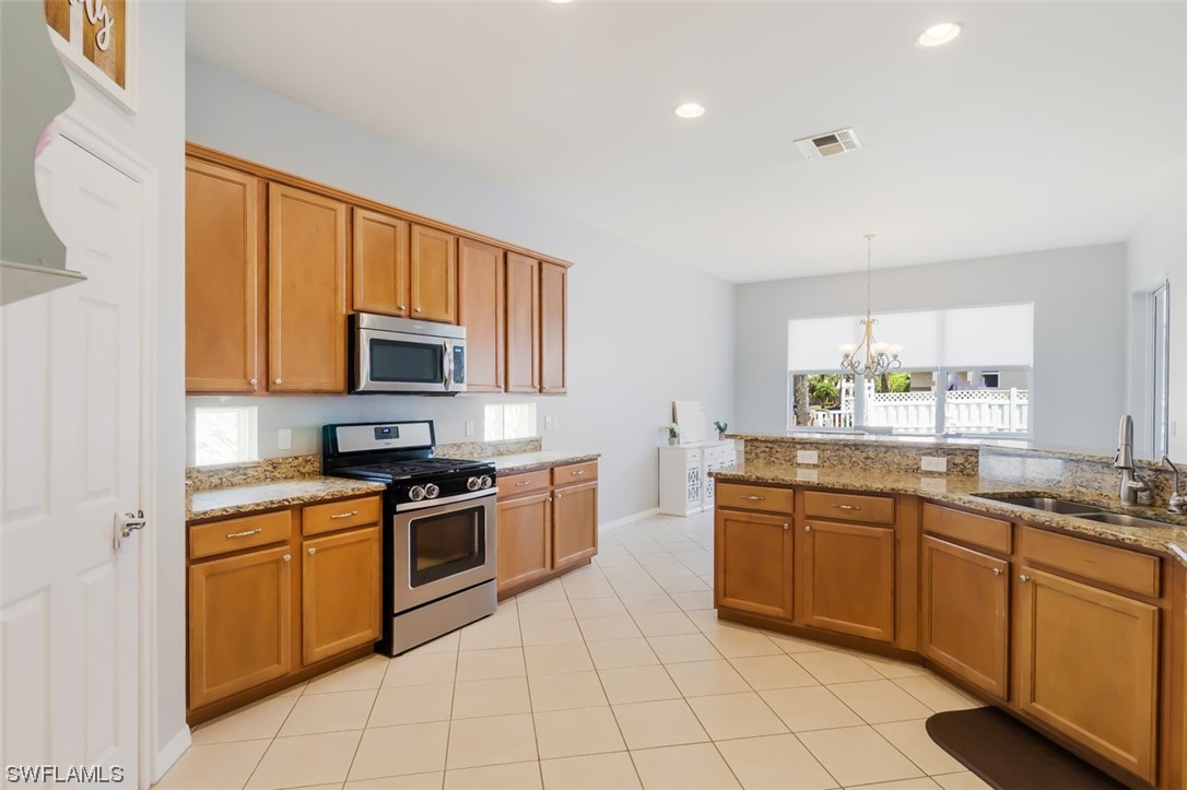 12893 Timber Ridge Drive Fort Myers, FL 33913 - Photo 17 of 30 a kitchen with stainless steel appliances granite countertop a sink and cabinets