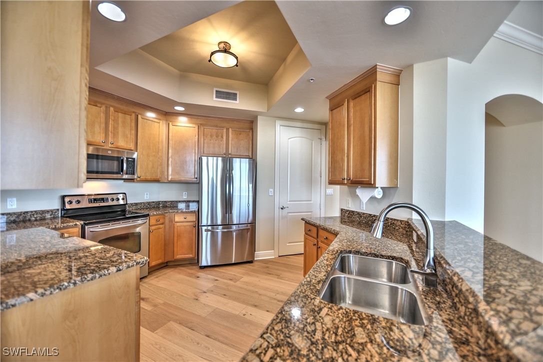 2104 West First Street, Unit 2804 Fort Myers, FL 33901 - Photo 12 of 49 a kitchen with stainless steel appliances granite countertop a stove refrigerator and cabinets