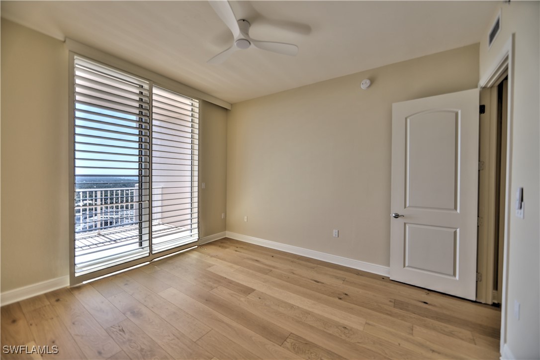 2104 West First Street, Unit 2804 Fort Myers, FL 33901 - Photo 27 of 49 an empty room with wooden floor and windows