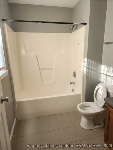 a white toilet sitting next to a bath tub and a shower