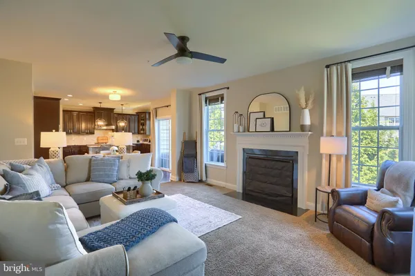 a living room with furniture and a view of kitchen