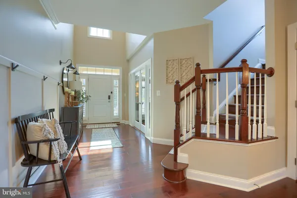 a dining room with wooden floor a chandelier a wooden table and chairs