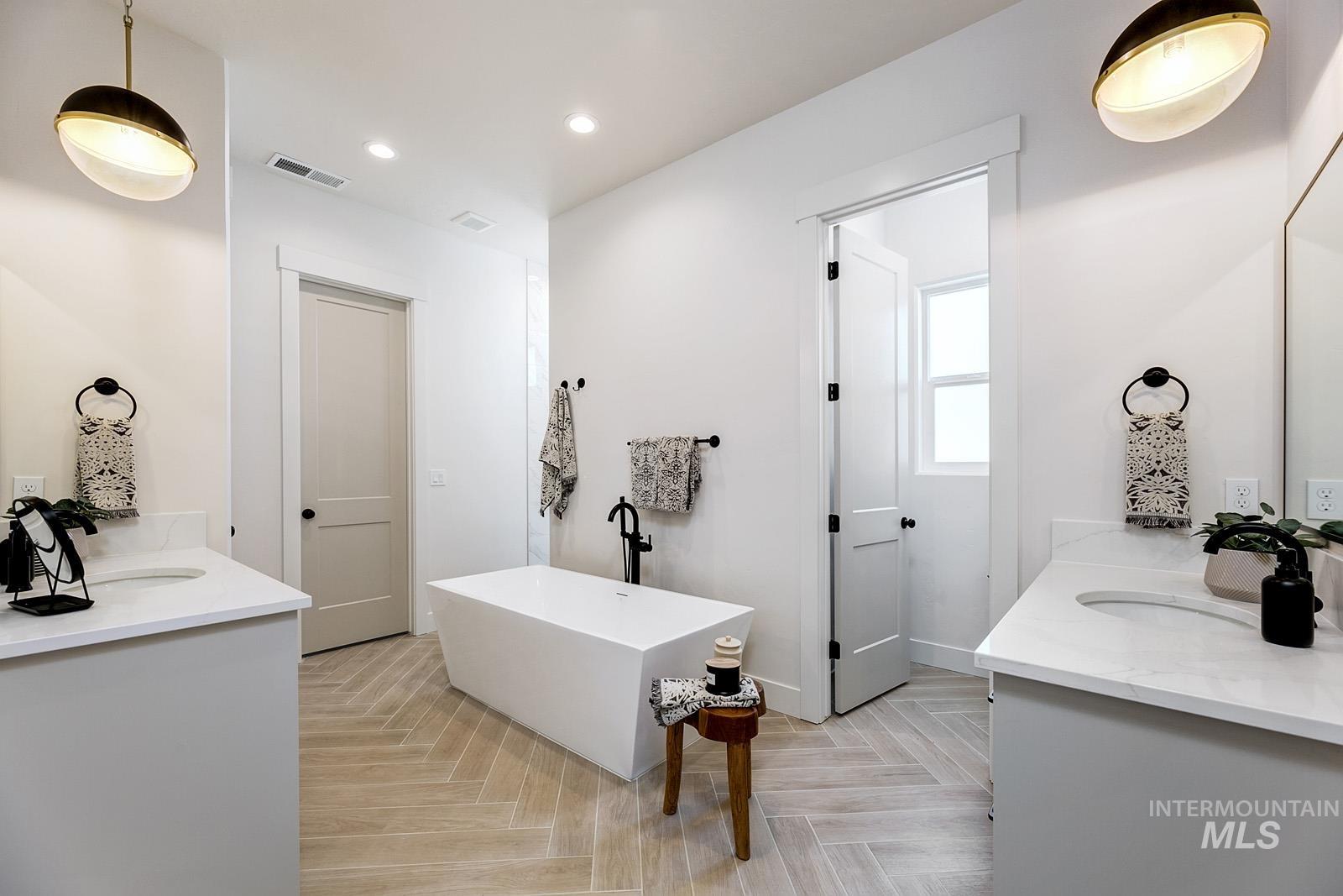 13660 North Spring Creek Way Boise, ID 83714 - Photo 14 of 42 Full bathroom featuring vanity, parquet flooring, a freestanding tub, and recessed lighting
