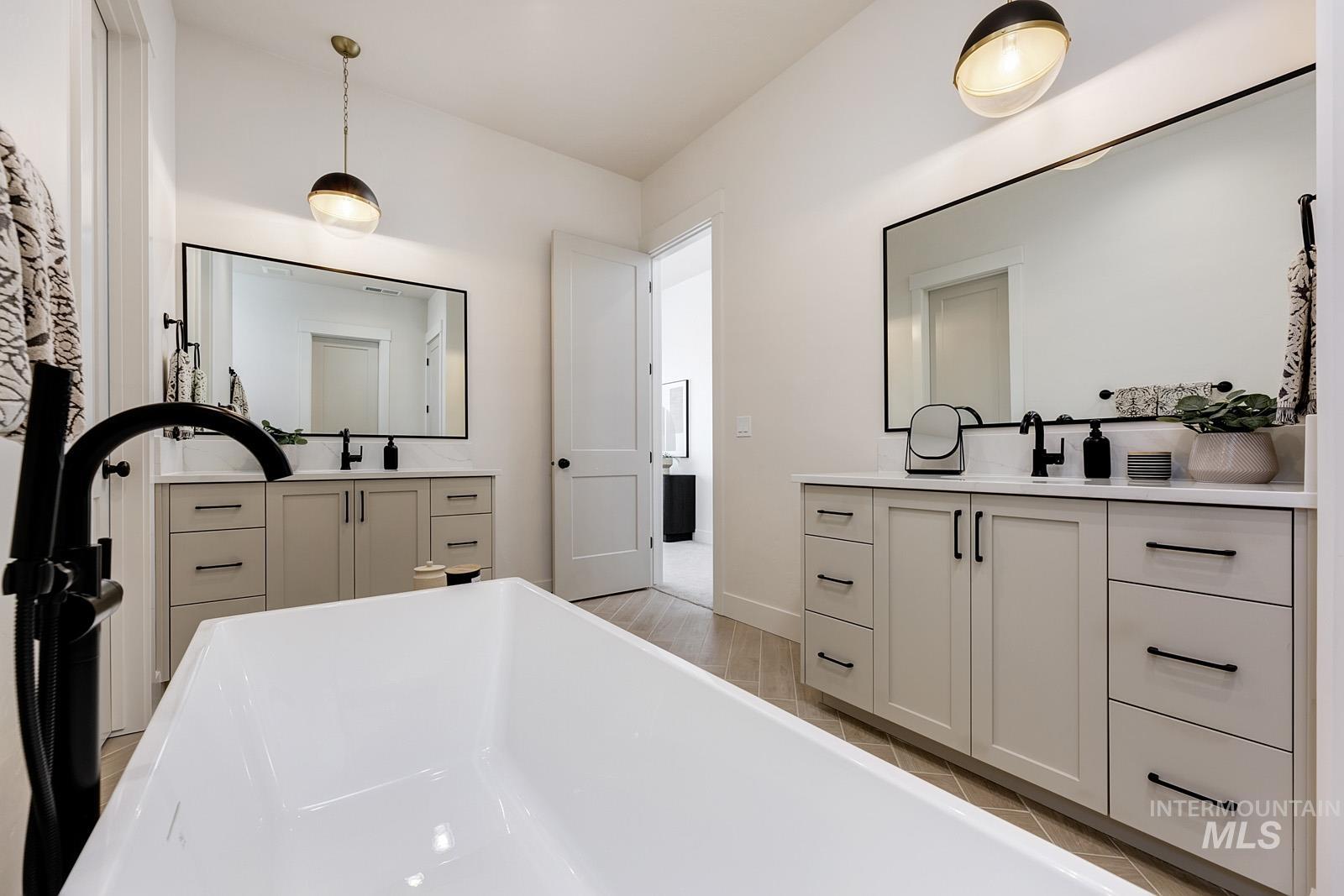 13660 North Spring Creek Way Boise, ID 83714 - Photo 16 of 42 Full bath featuring two vanities, a freestanding bath, and light wood-type flooring