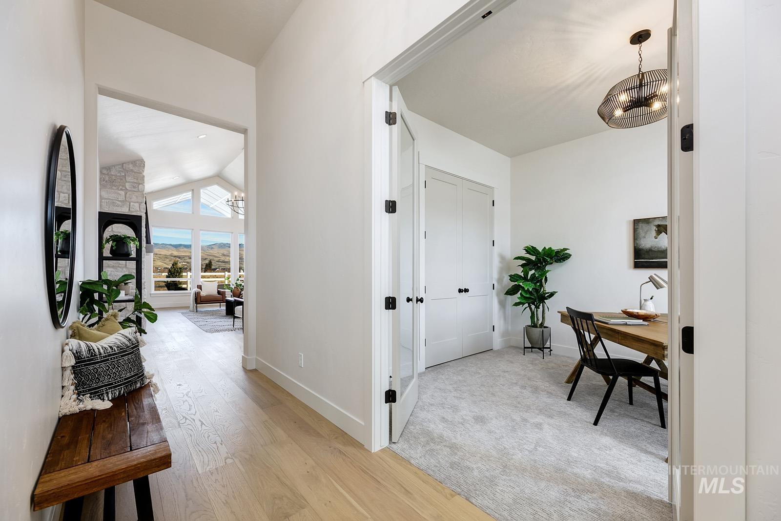 13660 North Spring Creek Way Boise, ID 83714 - Photo 19 of 42 Hall featuring lofted ceiling, light wood-style flooring, a mountain view, and hanging lights