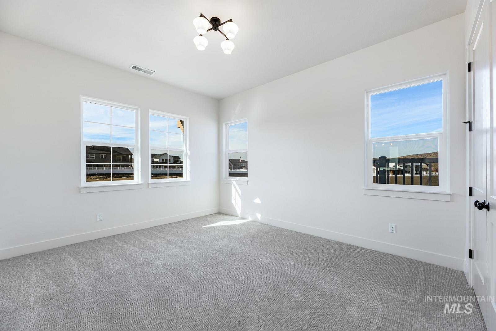 13660 North Spring Creek Way Boise, ID 83714 - Photo 21 of 42 Carpeted empty room with baseboards and hanging lights