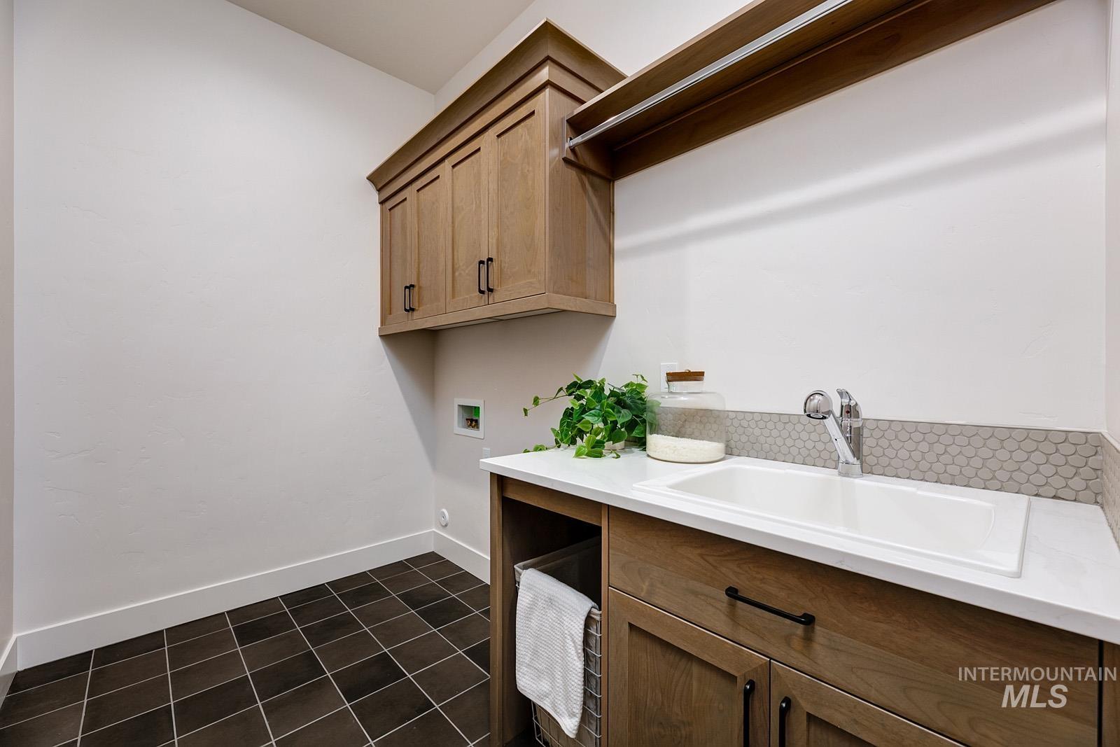 13660 North Spring Creek Way Boise, ID 83714 - Photo 26 of 42 Laundry area featuring dark tile patterned floors, washer hookup, and cabinet space