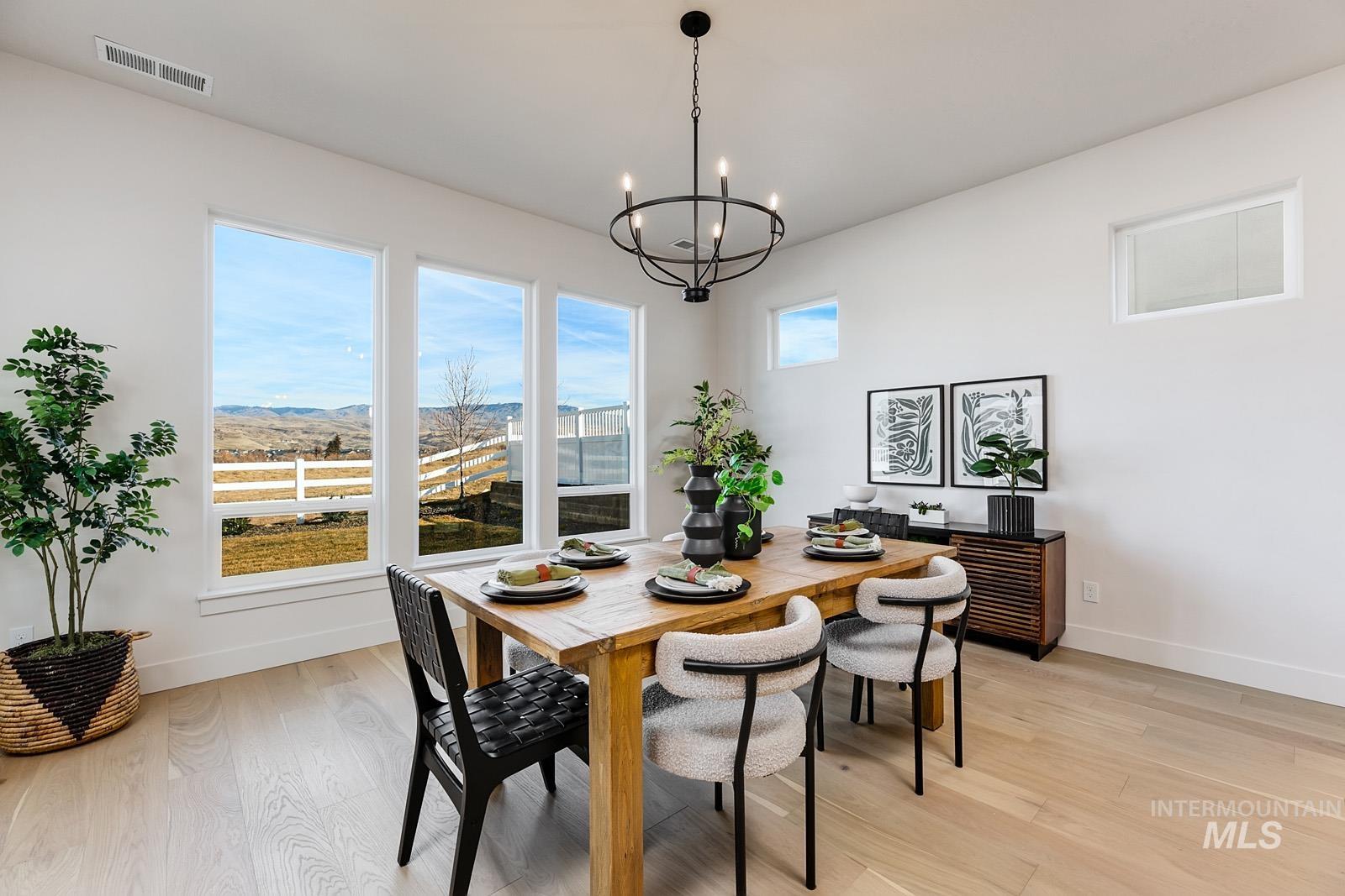 13660 North Spring Creek Way Boise, ID 83714 - Photo 8 of 42 Dining room with light wood-style flooring, hanging lights, and a mountain view