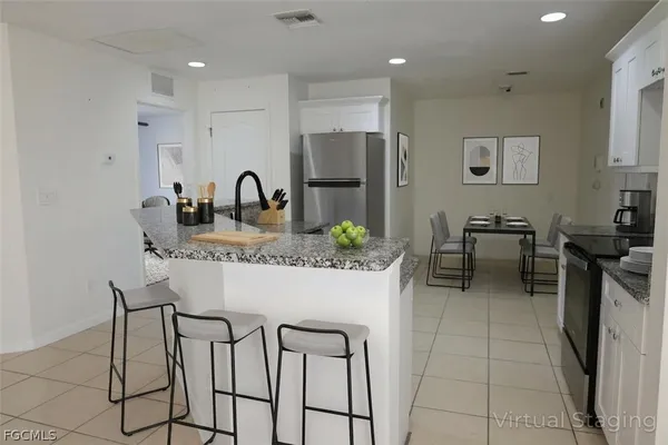 a kitchen with stainless steel appliances granite countertop a table and chairs in it