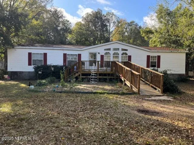 a view of a house with backyard and trees