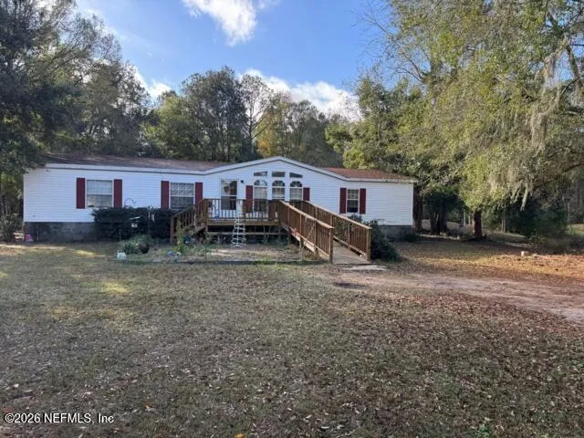 a view of a house with backyard and trees
