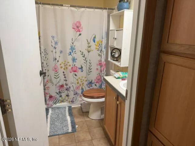 a white toilet sitting next to a shower curtain