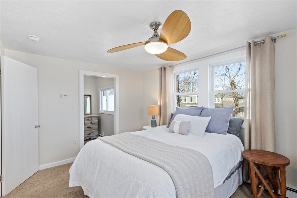 189 Wompatuck Road Hingham, MA 02043 - Photo 17 of 40 a bedroom with a bed and a chandelier