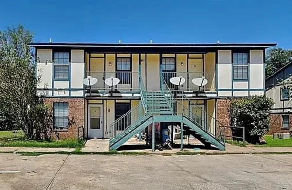 a view of a brick house with large windows and a table