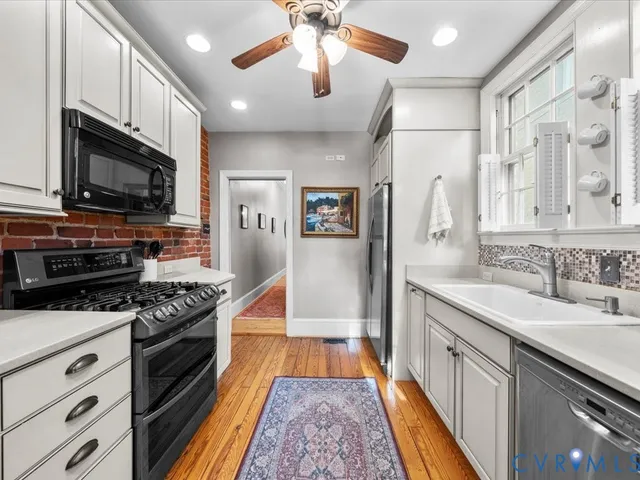 a kitchen with stainless steel appliances a stove sink microwave and cabinets