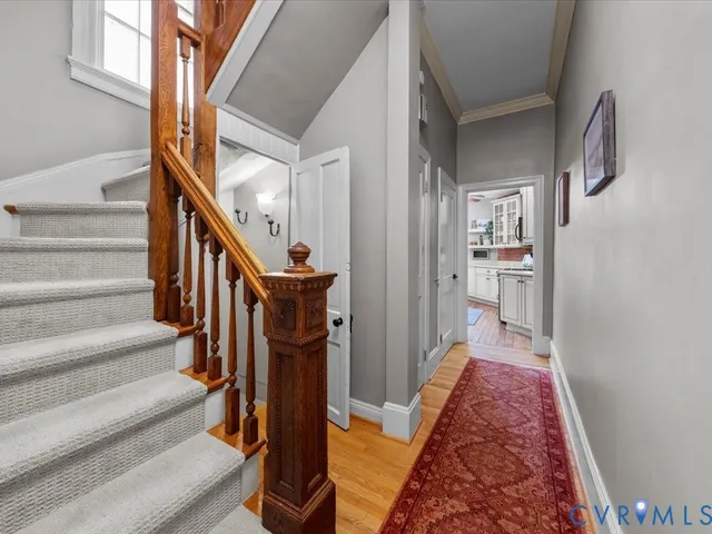 a view of hallway with wooden floor and stairs