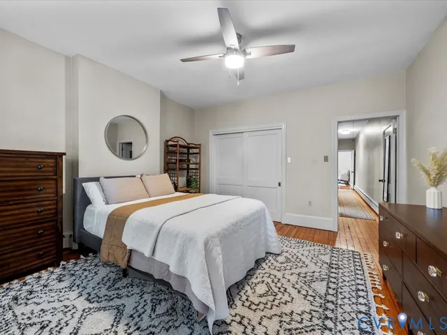 a bedroom with a bed and a lamp on dresser