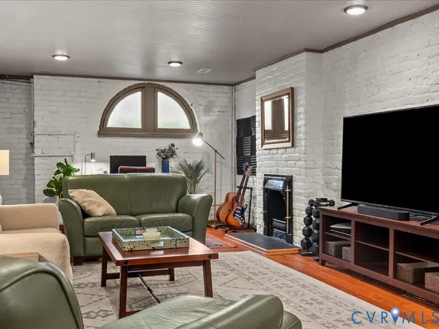 a living room with furniture a flat screen tv and a fireplace